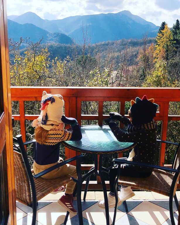 Εδώ τα δίδυμα κάθονται στο μπαλκονάκι του δωματίου και ποζάρουν στον φωτογραφικό φακό με φόντο το υπέροχο τοπίο.