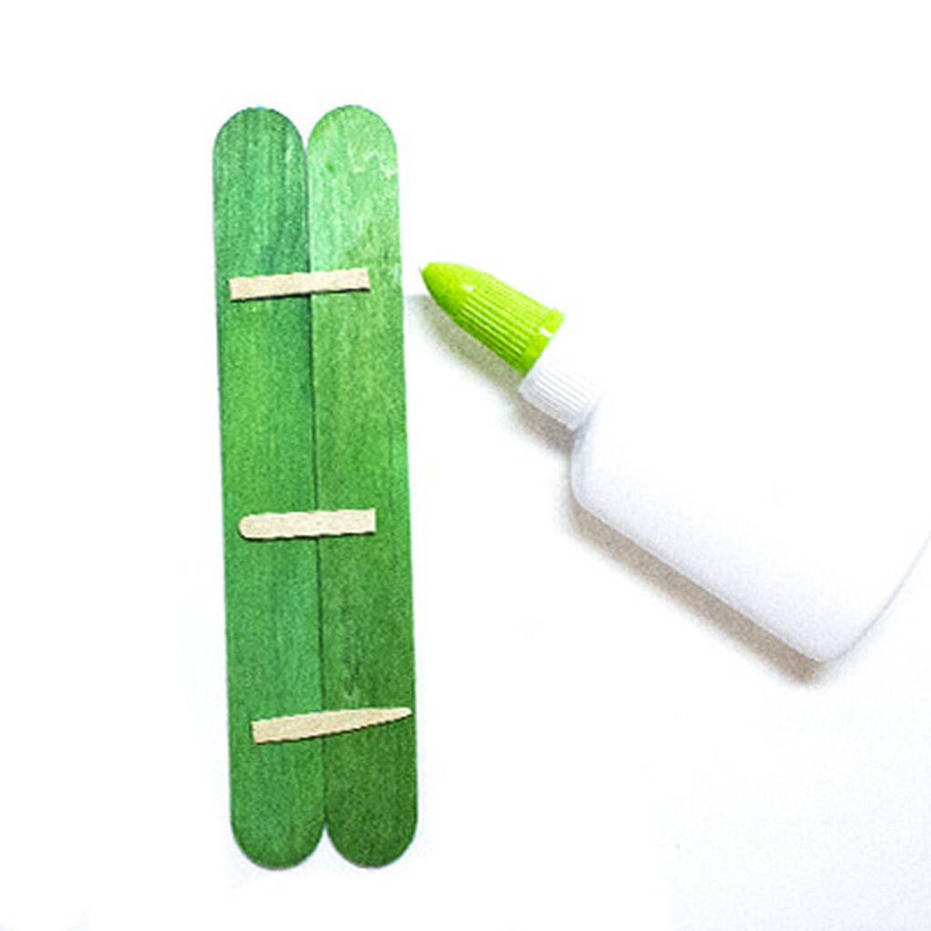 Για τον αρακά: Κολλήστε δύο ξυλάκια μεταξύ τους και βάψτε τα με πράσινο χρώμα. 