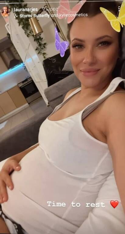 Η μέλλουσα μαμά ξεκουράζεται στον καναπέ και μας δείχνει τη φουσκωμένη της κοιλιά.