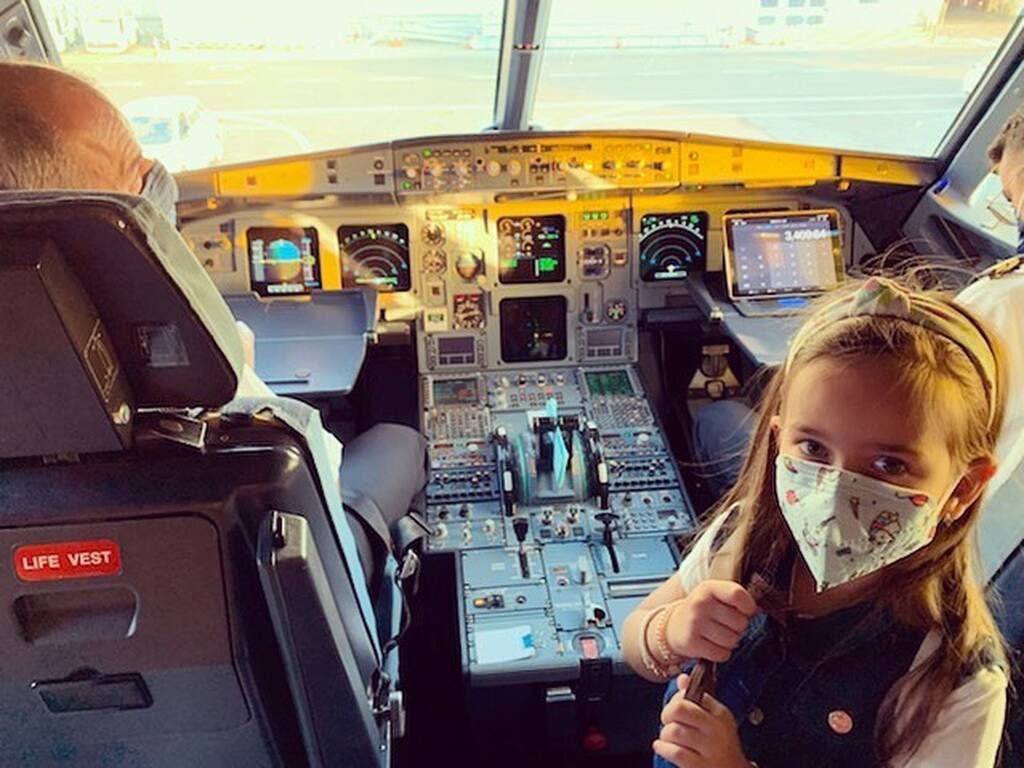 Η Ζένια αν και φοράει μάσκα, βρίσκεται στο πιλοτήριο και κοιτάζει με τα μεγάλα της μάτια τον φακό. 