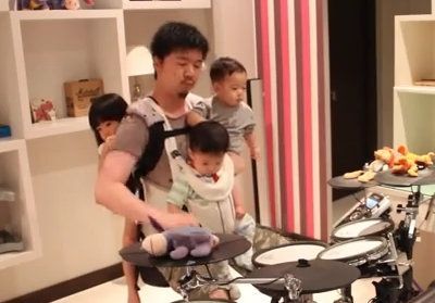 Μπαμπάς παίζει ντραμς έχοντας αγκαλιά και τα τρία του παιδιά! (βίντεο)