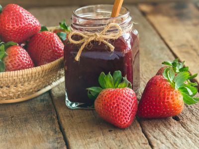 Μαρμελάδα φράουλα με μια κούπα καστανή ζάχαρη