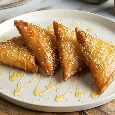 Τραγανά τυροπιτάκια με ανθόνερο, μέλι και σουσάμι