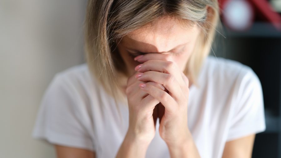 Stressed Sad Woman With Closed Eyes Keeps Her Hands Connected Near Her Face Close-up. The Concept Of