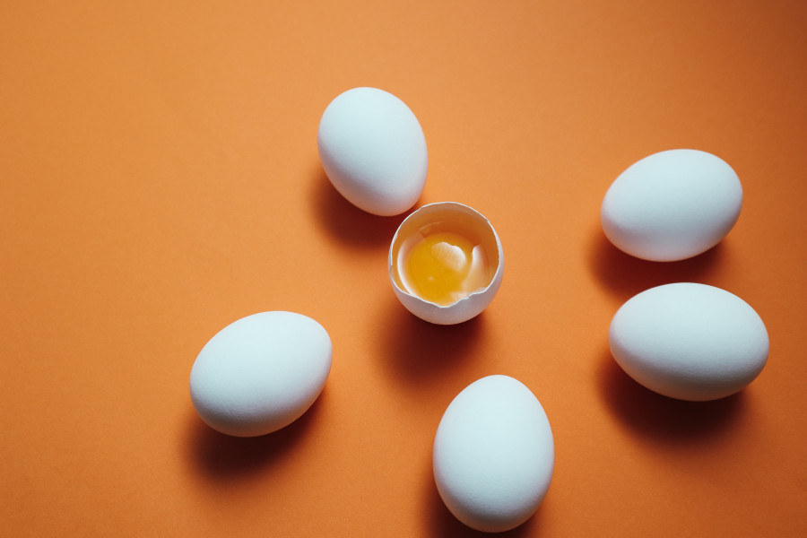 White Eggs And Egg Yolk On The Yellow Background. Egg Yolk In Egg Shell, Cracked Egg White Isolated