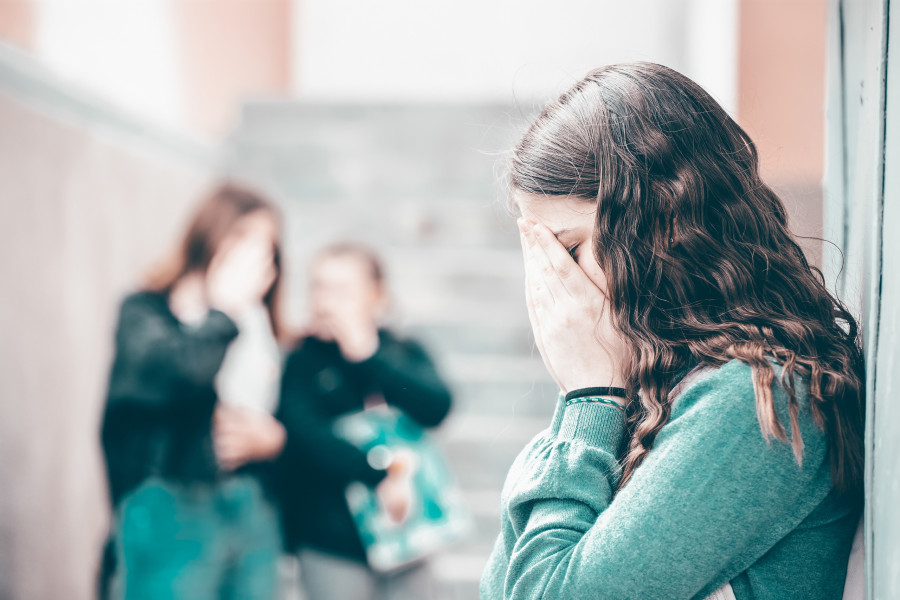 Girl being bullied at the school. Educational school isolation and bullying concept.