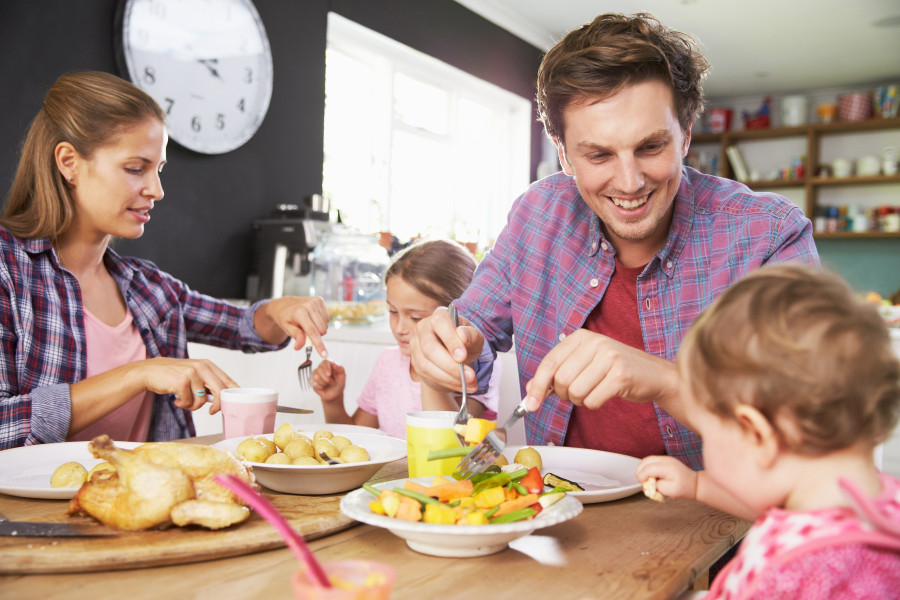 Family Eating Meal In Kitchen Together